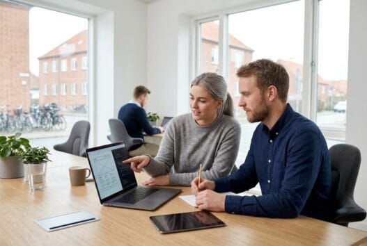 Skandinavisk webbureau i Årslev med team ved computere og dashboards i moderne kontor