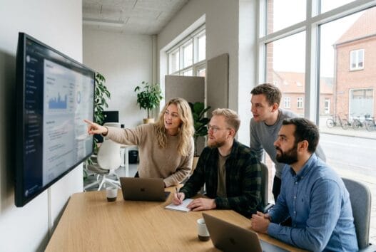 Moderne webbureau i frifelt (6280) med skandinavisk team ved computer og dashboards