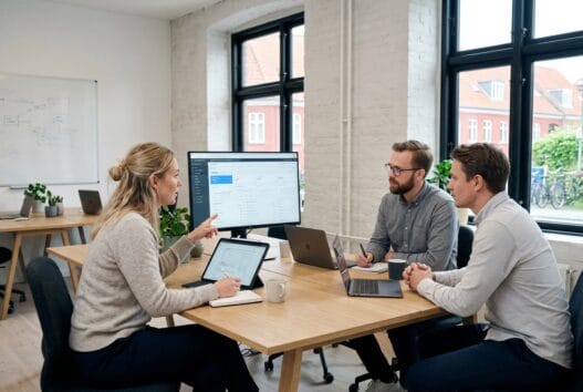 Dansk webbureau i Hammershøj med team ved computer og digitale dashboards i moderne kontor