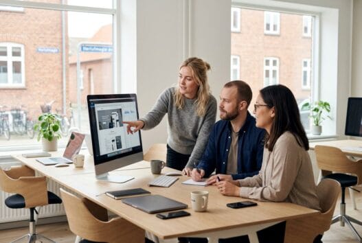 Moderne webbureau i Herlufmagle med dansk team, der arbejder ved computer i lyst kontormiljø