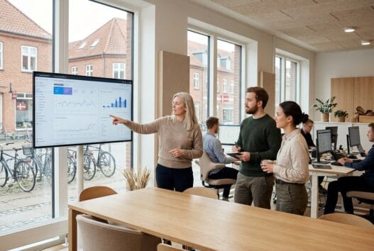 Moderne webbureau i Hobro med dansk team foran skærme og digitale dashboards