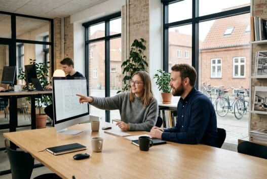 Dansk webbureau i Kyndby med team ved computer og digitale analyser i et moderne kontor