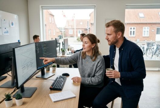 Dansk webbureau i Nørre Vedby med team foran computer og digitale dashboards i moderne kontor