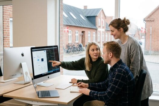 Moderne webbureau i ranum med dansk team ved computer og digitale dashboards