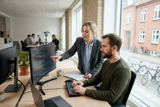 Realistisk kontorscene med dansk webbureau i rens, hvor et team arbejder med digitale løsninger