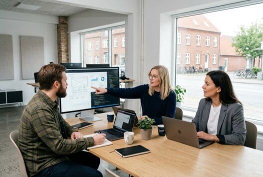 Moderne webbureau i Slagelse med skandinaviske kolleger foran skærme i et lyst kontor