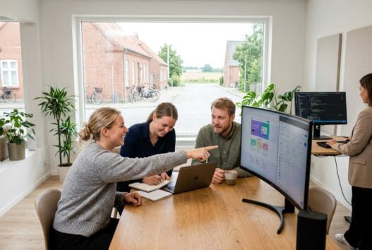 Moderne webbureau i Stenum med skandinaviske medarbejdere foran skærme og digitale dashboards