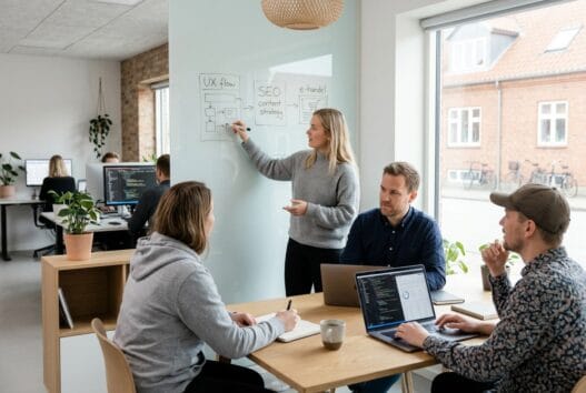 Skandinavisk team arbejder med webdesign og data på kontor i Uldum