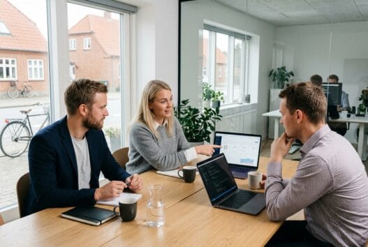 Moderne webbureau i Vilslev med dansk team, der arbejder ved computere med digitale dashboards